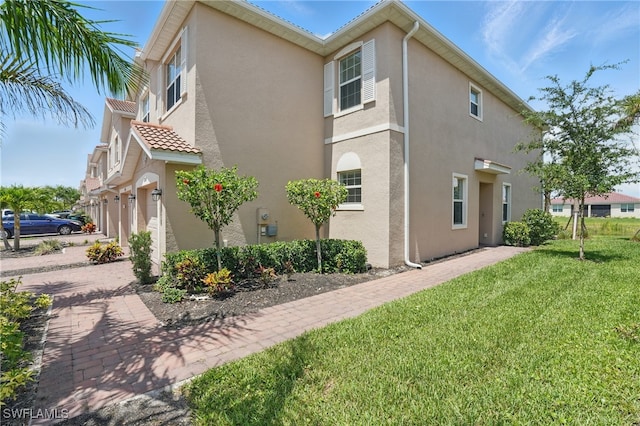 2810 Blossom Way, Naples, FL 34120 - view of side of home featuring stucco siding, a yard, a garage, and decorative driveway
