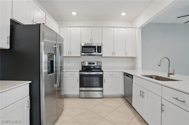 2810 Blossom Way, Naples, FL 34120 - kitchen featuring appliances with stainless steel finishes, a sink, light countertops, white cabinets, and light tile patterned flooring
