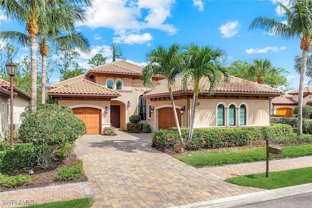 6419 Vivaldi Ct, Naples, FL 34113 - mediterranean / spanish home featuring stucco siding, a garage, a tiled roof, and decorative driveway