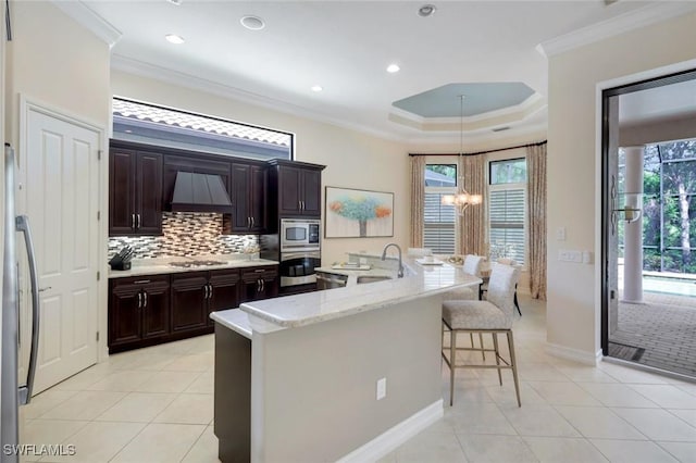 6419 Vivaldi Ct, Naples, FL 34113 - kitchen with a sink, a chandelier, custom range hood, crown molding, and a kitchen breakfast bar