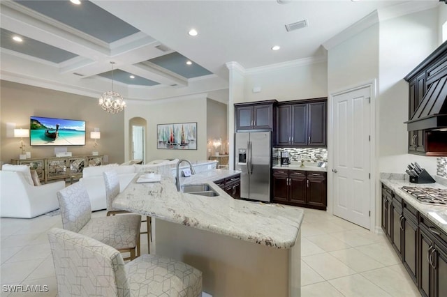 6419 Vivaldi Ct, Naples, FL 34113 - kitchen with stainless steel appliances, a sink, open floor plan, arched walkways, and light tile patterned flooring