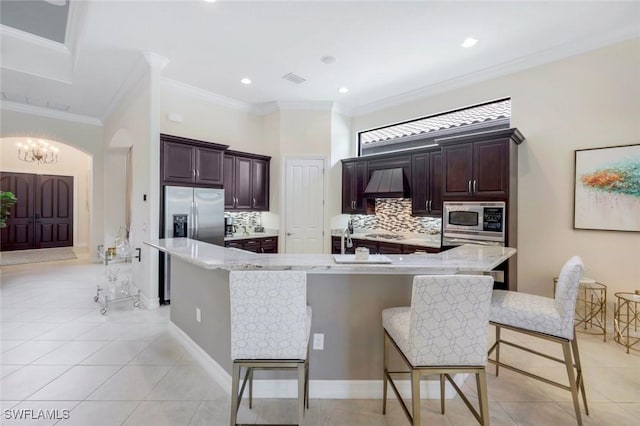 6419 Vivaldi Ct, Naples, FL 34113 - kitchen with appliances with stainless steel finishes, tasteful backsplash, a kitchen breakfast bar, ornamental molding, and light tile patterned flooring