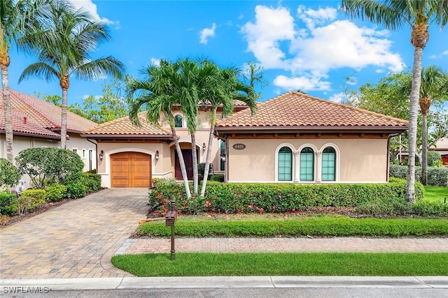 6419 Vivaldi Ct, Naples, FL 34113 - mediterranean / spanish house with an attached garage, stucco siding, decorative driveway, and a tile roof