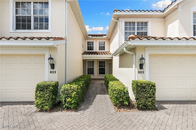 1335 Henley St Unit 802, Naples, FL 34105 - townhome / multi-family property with a tile roof, stucco siding, an attached garage, and decorative driveway
