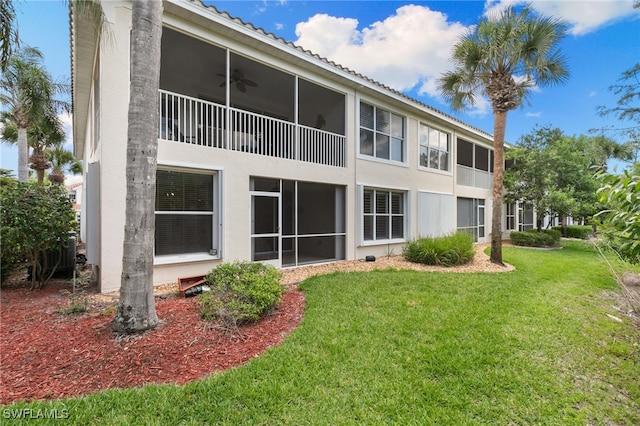 1335 Henley St Unit 802, Naples, FL 34105 - back of house with stucco siding, a yard, a ceiling fan, and a sunroom