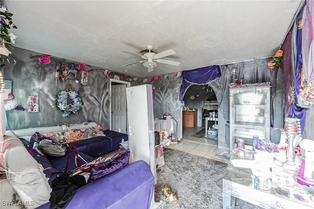living area with a ceiling fan, arched walkways, and tile patterned flooring