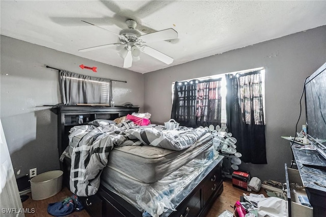 bedroom featuring wood finished floors, a ceiling fan, and multiple windows