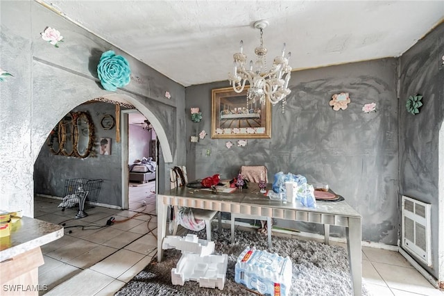 dining room featuring tile patterned flooring, a chandelier, arched walkways, and heating unit
