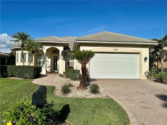 28171 L Burton Fletcher Ct, Bonita Springs, FL 34135 - mediterranean / spanish home featuring decorative driveway, a garage, stucco siding, and a tiled roof