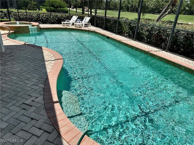 28171 L Burton Fletcher Ct, Bonita Springs, FL 34135 - view of swimming pool with glass enclosure, a pool with connected hot tub, and a patio area
