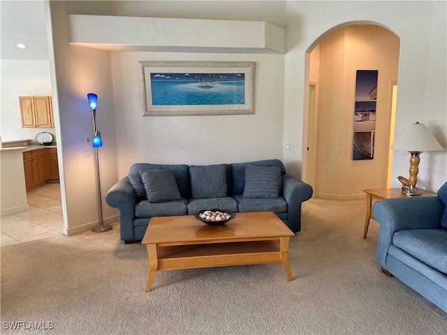 28171 L Burton Fletcher Ct, Bonita Springs, FL 34135 - living room featuring light colored carpet, arched walkways, and baseboards