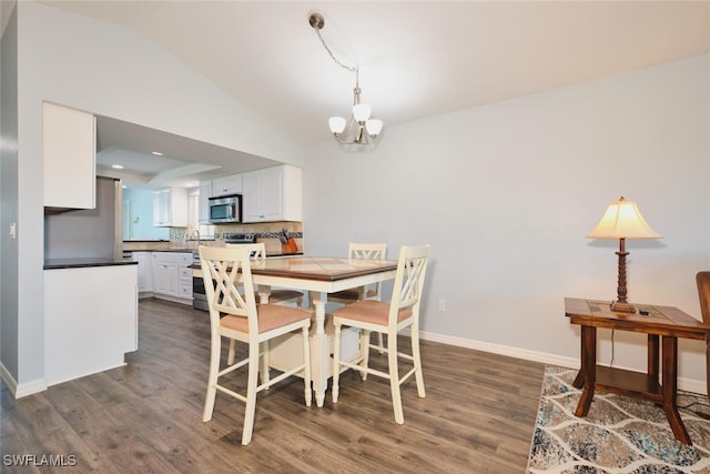 1124 SW 48th Ter Unit 208, Cape Coral, FL 33914 - dining space featuring lofted ceiling, dark wood-style flooring, a chandelier, and baseboards