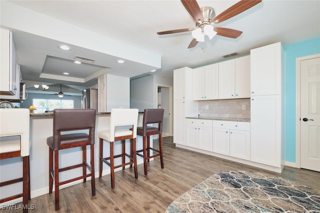 1124 SW 48th Ter Unit 208, Cape Coral, FL 33914 - kitchen featuring freestanding refrigerator, ceiling fan, wood finished floors, tasteful backsplash, and a kitchen breakfast bar