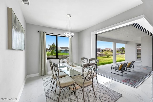 1409 SW 24th St, Cape Coral, FL 33991 - dining space featuring light marble finish floors, plenty of natural light, a chandelier, and baseboards