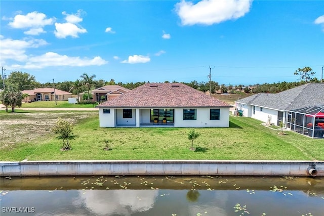 1409 SW 24th St, Cape Coral, FL 33991 - rear view of house with a lawn, a water view, stucco siding, and glass enclosure