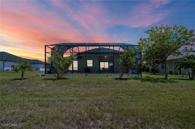 3410 NW 17th Ln, Cape Coral, FL 33993 - back of property at dusk featuring a yard and glass enclosure