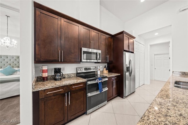 3410 NW 17th Ln, Cape Coral, FL 33993 - kitchen with appliances with stainless steel finishes, light stone countertops, dark brown cabinetry, a chandelier, and recessed lighting