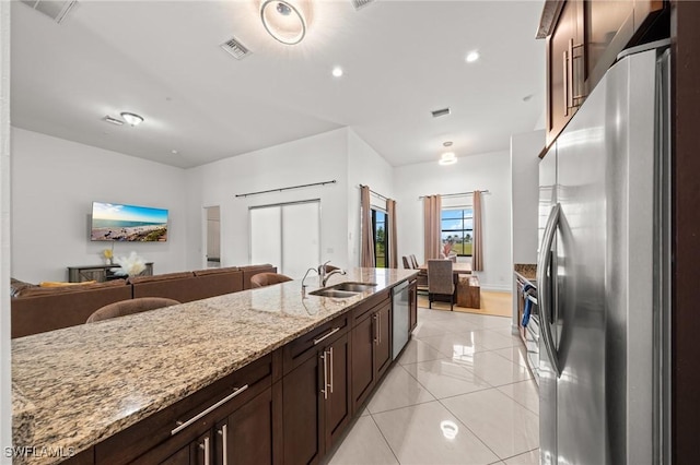 3410 NW 17th Ln, Cape Coral, FL 33993 - kitchen featuring stainless steel appliances, a sink, light stone counters, open floor plan, and light tile patterned flooring
