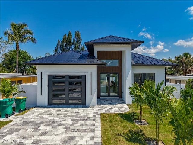 857 95th Ave N, Naples, FL 34108 - contemporary house with a standing seam roof, a garage, metal roof, stucco siding, and driveway