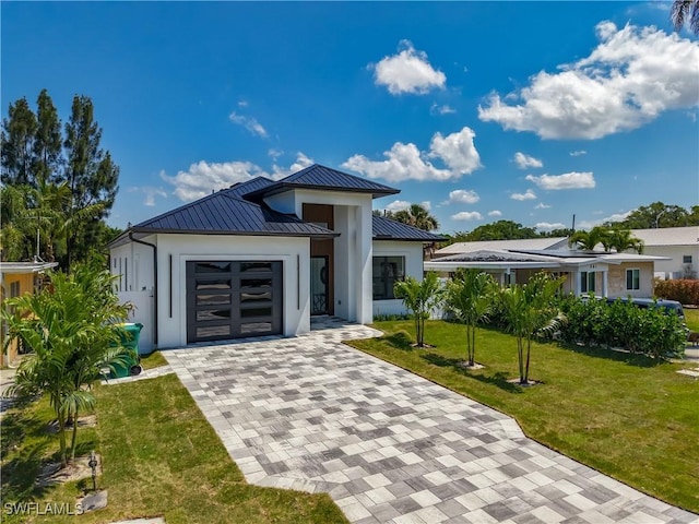 857 95th Ave N, Naples, FL 34108 - contemporary home featuring decorative driveway, a garage, a front yard, a standing seam roof, and stucco siding