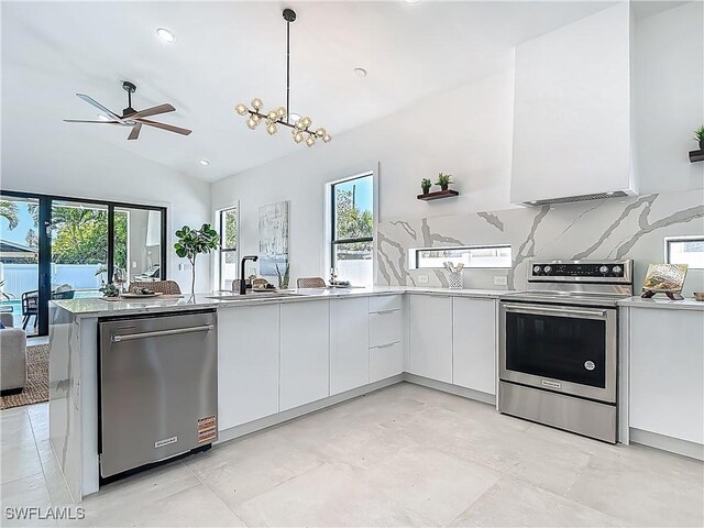 857 95th Ave N, Naples, FL 34108 - kitchen featuring stainless steel appliances, modern cabinets, white cabinetry, healthy amount of natural light, and vaulted ceiling