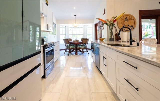 2535 River Reach Dr, Naples, FL 34104 - kitchen featuring appliances with stainless steel finishes, plenty of natural light, and white cabinetry