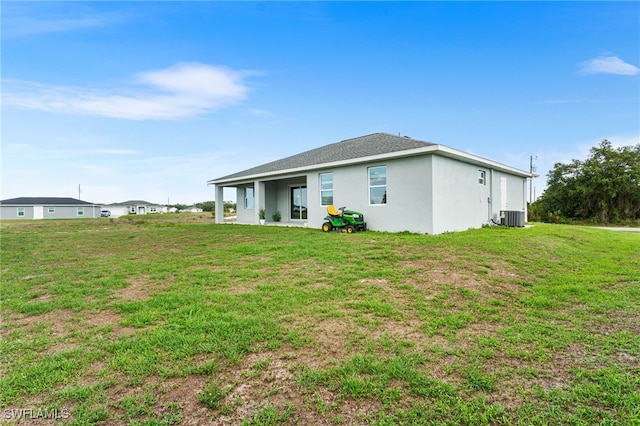 1049 Solar Ct, Labelle, FL 33935 - rear view of property with central AC, stucco siding, and a yard