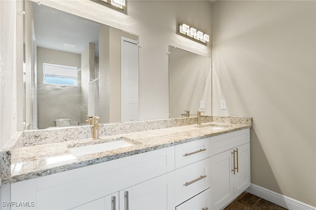 1049 Solar Ct, Labelle, FL 33935 - bathroom with double vanity, baseboards, wood finished floors, and toilet