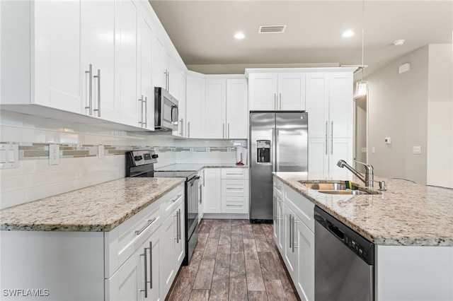 1049 Solar Ct, Labelle, FL 33935 - kitchen with stainless steel appliances, a sink, white cabinets, backsplash, and recessed lighting