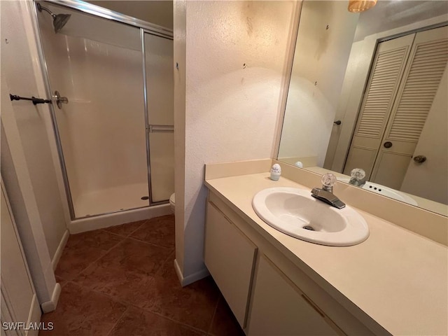 4186 27th Ct SW Unit 105, Naples, FL 34116 - full bathroom with a stall shower, toilet, vanity, tile patterned floors, and baseboards