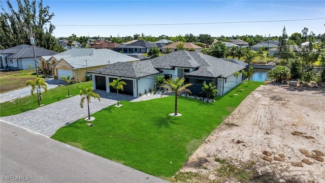 419 NW 7th Ave, Cape Coral, FL 33993 - single story home featuring decorative driveway, a residential view, a garage, and a front yard
