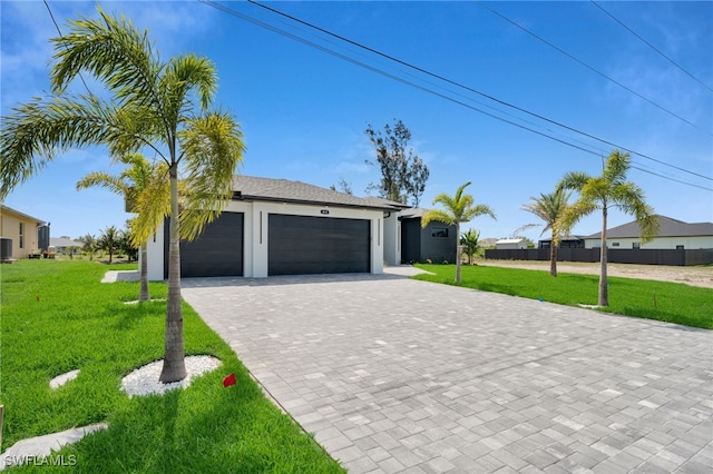 419 NW 7th Ave, Cape Coral, FL 33993 - view of front of house featuring decorative driveway, an attached garage, stucco siding, and central AC