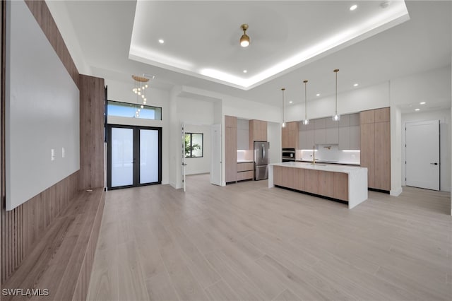 419 NW 7th Ave, Cape Coral, FL 33993 - kitchen with modern cabinets, appliances with stainless steel finishes, light countertops, a raised ceiling, and a center island with sink