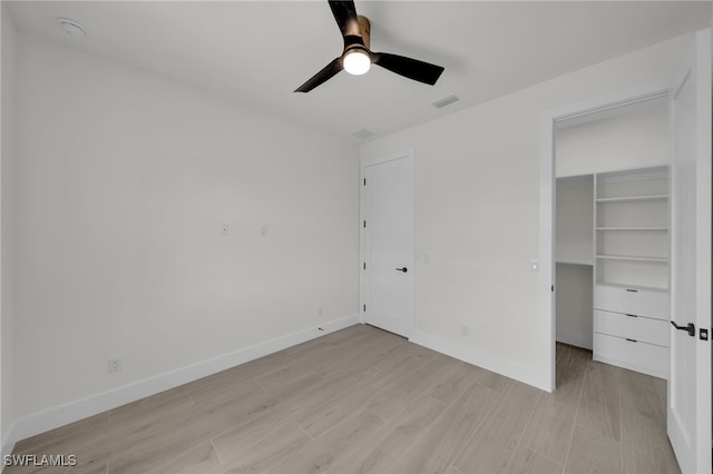 419 NW 7th Ave, Cape Coral, FL 33993 - unfurnished bedroom featuring light wood-style flooring, a spacious closet, baseboards, and ceiling fan