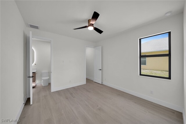 419 NW 7th Ave, Cape Coral, FL 33993 - unfurnished bedroom featuring light wood-type flooring, baseboards, and ensuite bathroom