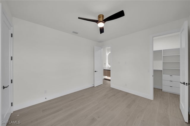 419 NW 7th Ave, Cape Coral, FL 33993 - unfurnished bedroom with light wood finished floors, baseboards, a spacious closet, ceiling fan, and a closet