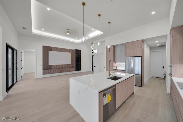 419 NW 7th Ave, Cape Coral, FL 33993 - kitchen featuring modern cabinets, stainless steel appliances, a sink, light wood-style floors, and an island with sink