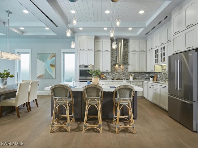 242 2nd Ave S, Naples, FL 34102 - kitchen with appliances with stainless steel finishes, wall chimney exhaust hood, backsplash, wood finished floors, and recessed lighting