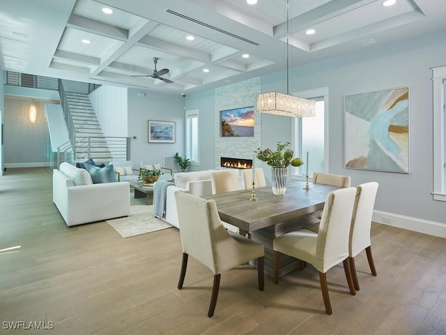 242 2nd Ave S, Naples, FL 34102 - dining area featuring beam ceiling, coffered ceiling, light wood-type flooring, baseboards, and a fireplace