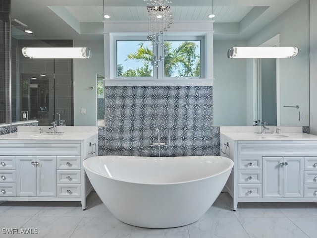 242 2nd Ave S, Naples, FL 34102 - full bath featuring marble finish flooring, tile walls, a freestanding tub, two vanities, and wood ceiling