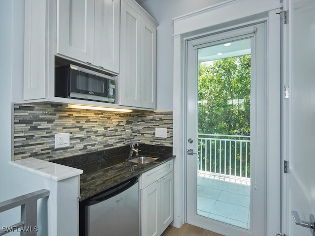 242 2nd Ave S, Naples, FL 34102 - kitchen with black microwave, a sink, fridge, tasteful backsplash, and white cabinets