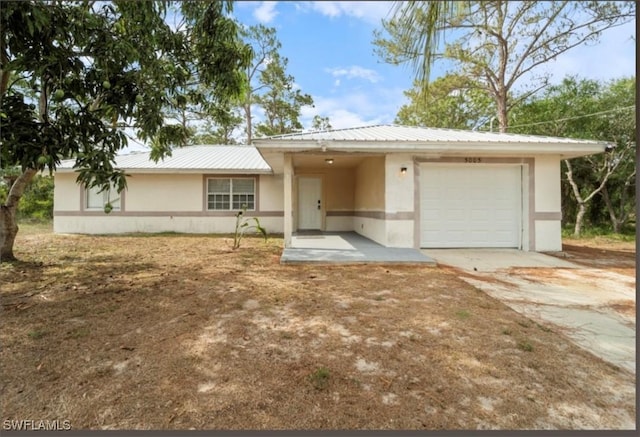 5005 Squaw Ln, Labelle, FL 33935 - ranch-style home featuring stucco siding, an attached garage, metal roof, and concrete driveway