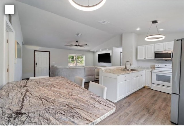 5005 Squaw Ln, Labelle, FL 33935 - kitchen featuring appliances with stainless steel finishes, a sink, lofted ceiling, a peninsula, and open floor plan