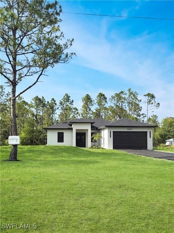 3247 72nd Ave NE, Naples, FL 34120 - view of front of home featuring driveway, a garage, a front lawn, stucco siding, and a shingled roof