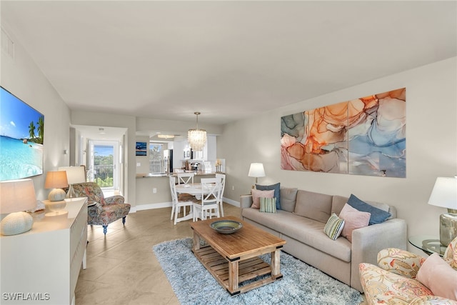 741 S Collier Blvd Unit 302, Marco Island, FL 34145 - living room with light tile patterned floors, a chandelier, and baseboards