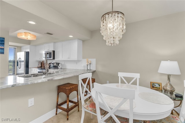 741 S Collier Blvd Unit 302, Marco Island, FL 34145 - kitchen featuring stainless steel appliances, light stone countertops, white cabinets, recessed lighting, and a peninsula