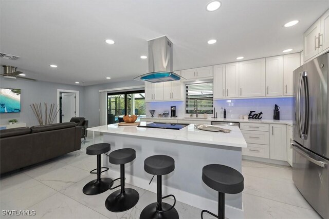 52 Fairview Blvd, Fort Myers Beach, FL 33931 - kitchen with appliances with stainless steel finishes, island exhaust hood, open floor plan, a breakfast bar, and white cabinets