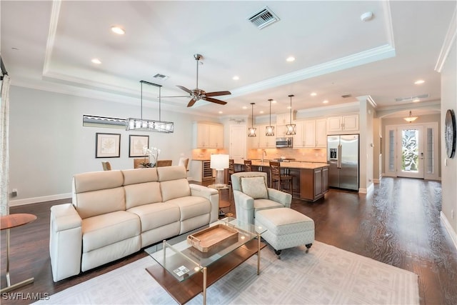 23778 Pebble Pointe Ln, Estero, FL 34135 - living area featuring a raised ceiling, crown molding, ceiling fan, baseboards, and dark wood-type flooring