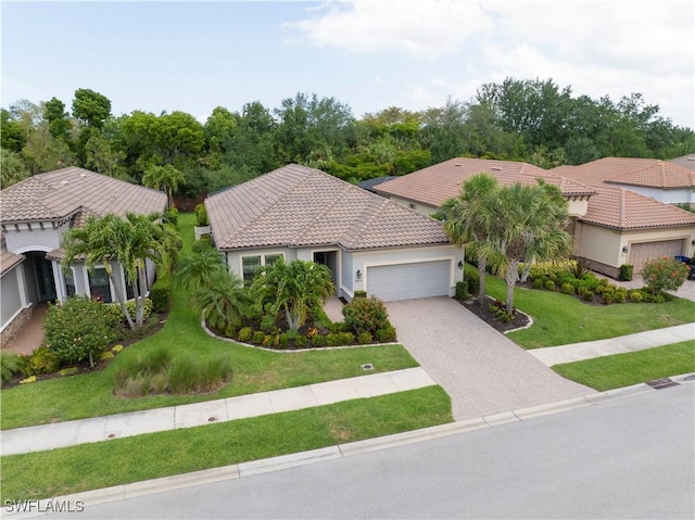 23778 Pebble Pointe Ln, Estero, FL 34135 - mediterranean / spanish-style home with an attached garage, a tile roof, driveway, a front lawn, and stucco siding