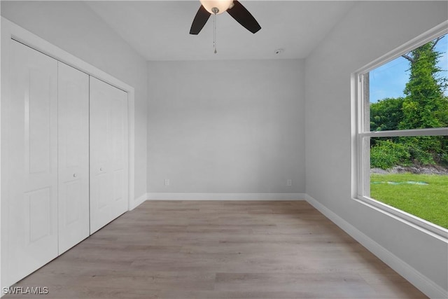 4201 17th St SW, Lehigh Acres, FL 33976 - unfurnished bedroom with multiple windows, light wood-style flooring, a closet, and ceiling fan